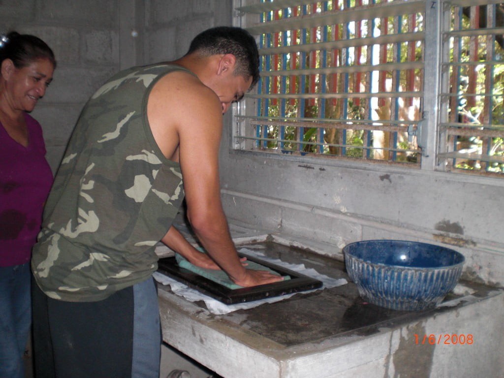 Miguel in the process of squeezing the water out from the 'pasta' of food pulp and paper fibers