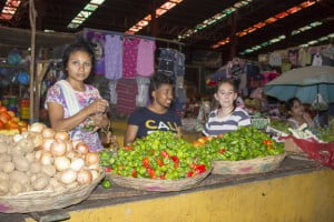 Nia and Enya help their vendor sell vegetables. 