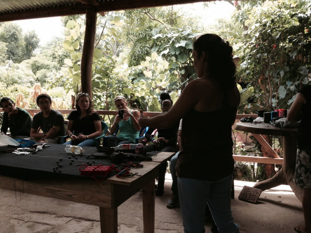 Maritza explaining how to make jewelry out of local seeds at Mujeres del Plomo