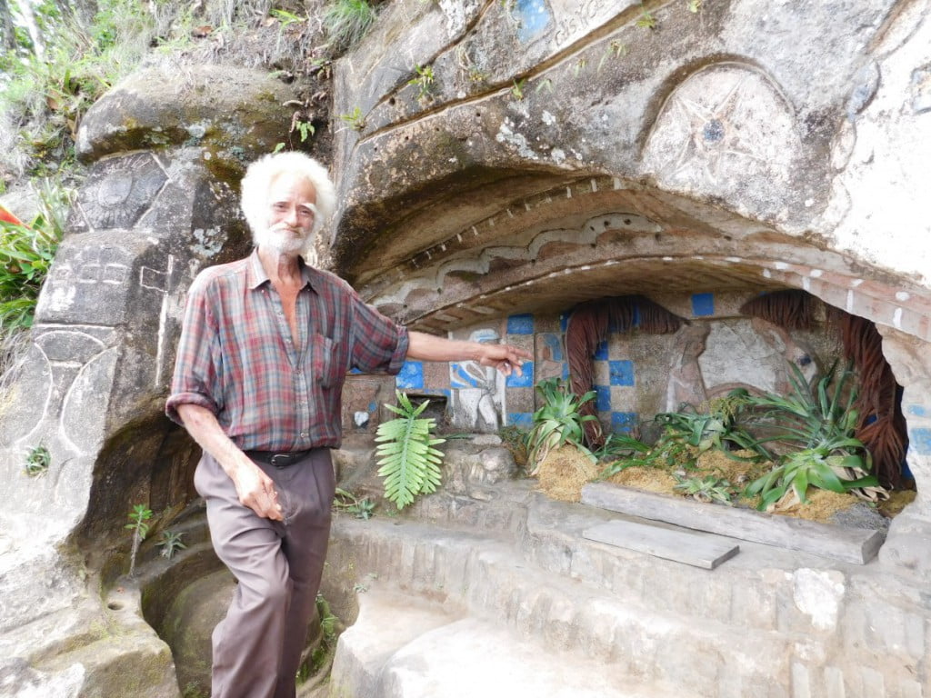 Nicaraguan artist Don Alberto, posing with some of the carvings he made on this cliff.