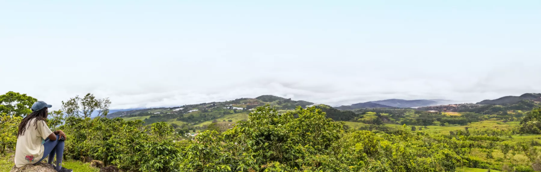 Student sitting on a hill looking out at a beautiful view