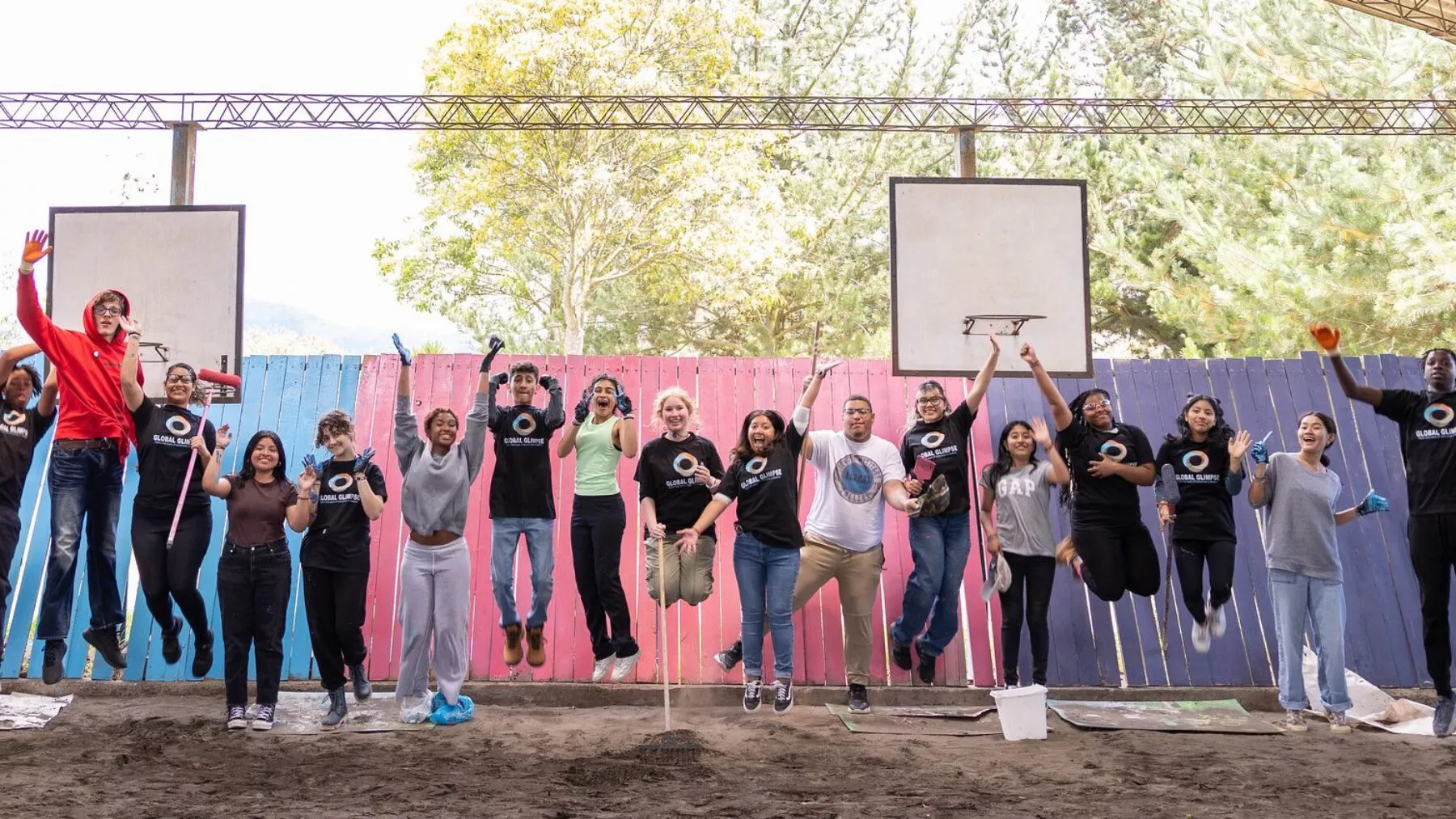 Group of students in front of multicolored walk mid jump