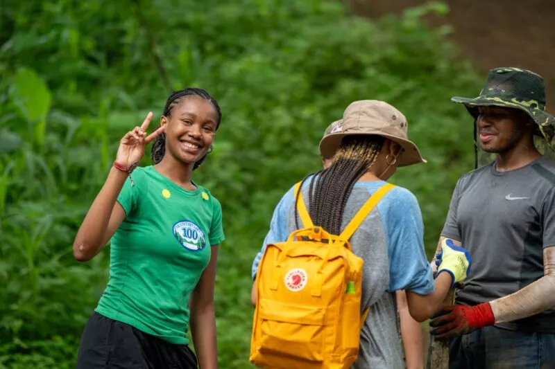 Student smiling and making peace sign fingers at the camera